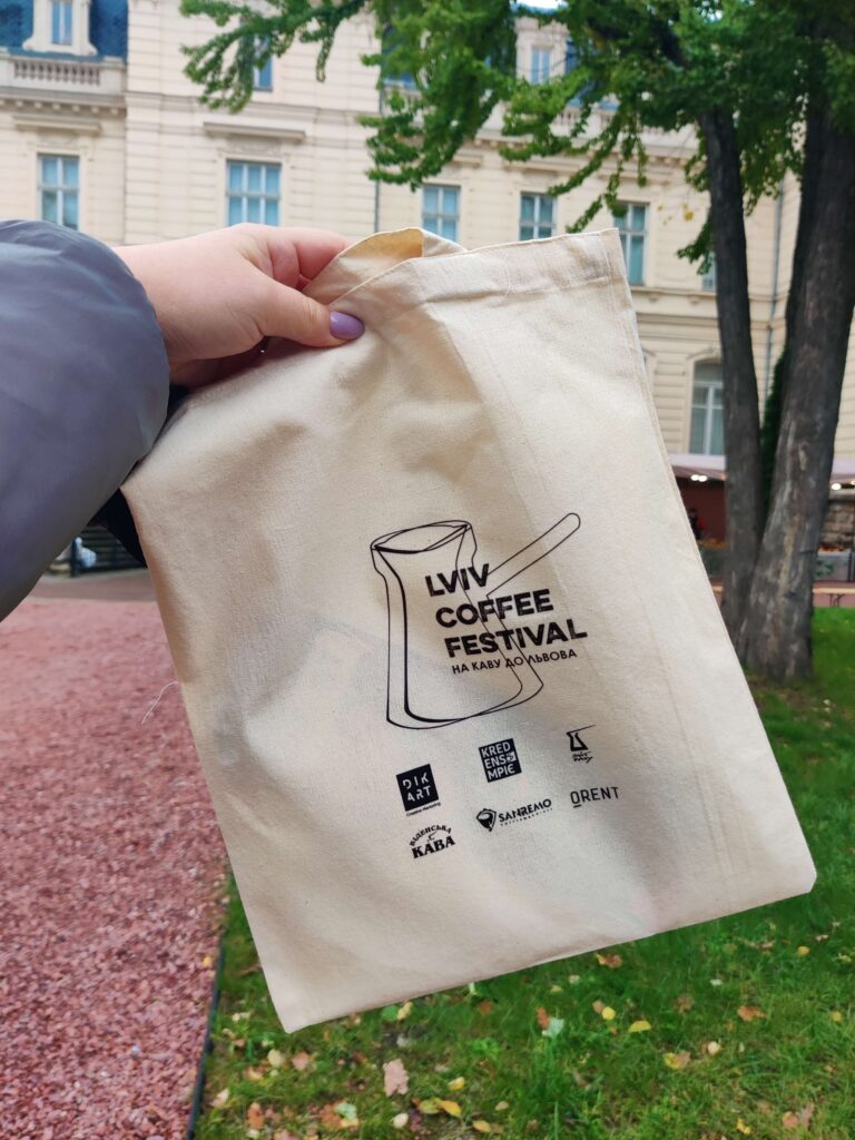Shopper s kofejnogo festivalya Lviv Coffee Fest Экошоппер Lviv Coffee Festival с логотипом фестиваля в руке на фоне городского парка